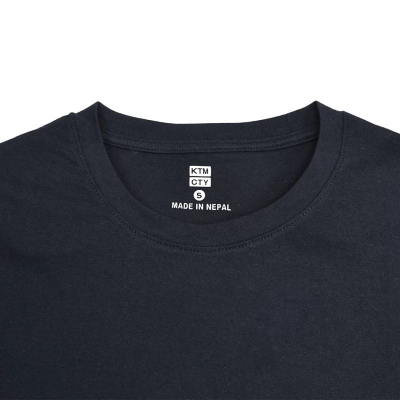 A female and male model standing back-to-back wearing the unisex KTMCTY Core Flex Crew Neck T-Shirt; the woman is wearing light grey and the man is wearing black. 6