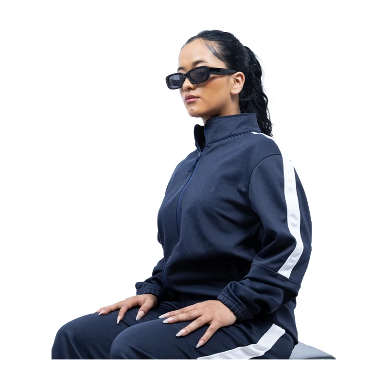 A male and female model standing back-to-back wearing the unisex KTMCTY Strike Track Jacket in grey and navy blue, featuring a classic white stripe down the sleeves 2