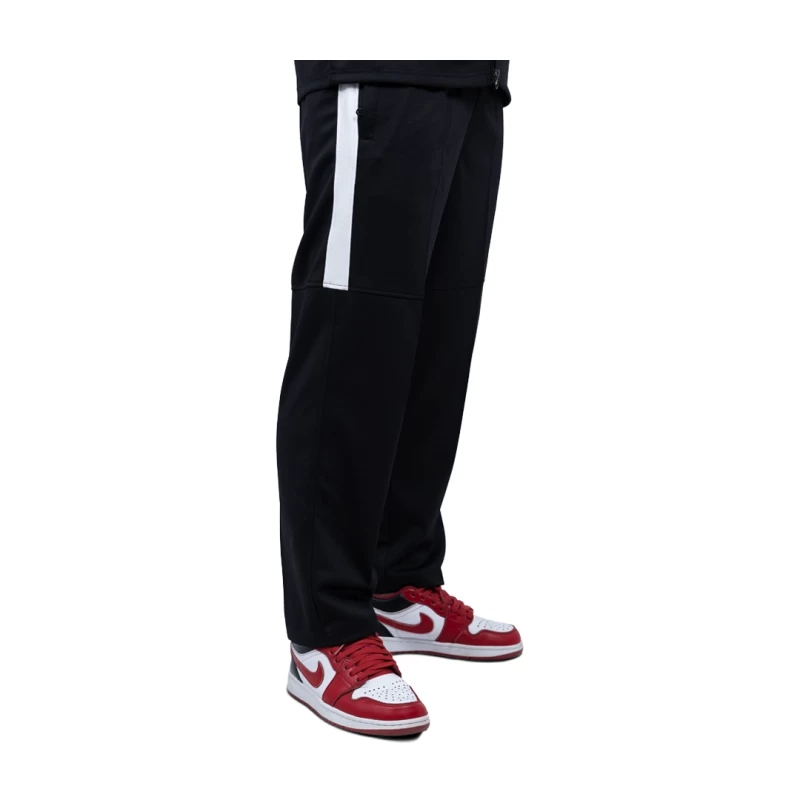 close-up of a person wearing black KTM CTY Strike Track Trousers featuring a bold white side stripe on the upper leg