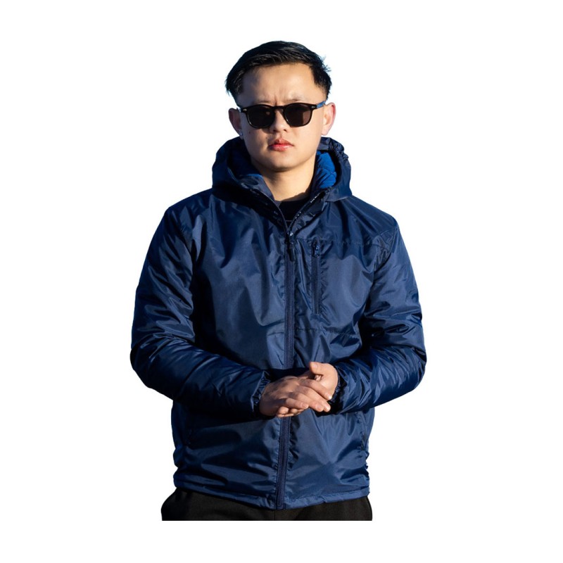 A male model wearing sunglasses and a navy blue KTM CTY Trailhawk Jacket, featuring an insulated, padded design with a full front zipper and hood for winter weather protection.