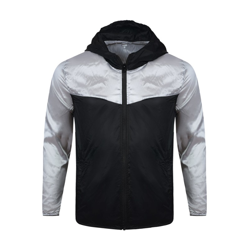 Front view of a male model styling a vibrant red and blue color-block lightweight windcheater jacket. This casual Unisex Windbreaker Jacket features a full zipper and a protective hood, making it a great outer layer for summer wear jacket. 3