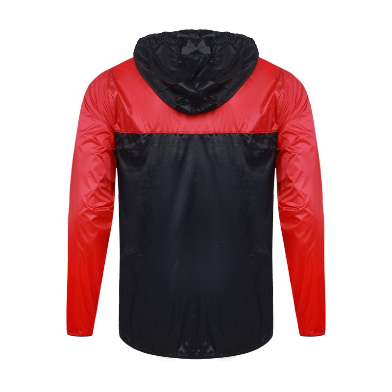 A smiling male model wearing the lightweight SkyShield Windcheater Jacket, featuring a bold red and bright blue color-block design, a full front zipper and an adjustable hood 5
