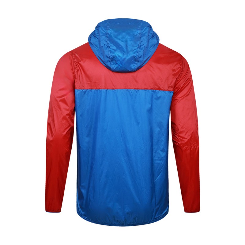 A smiling male model wearing the lightweight SkyShield Windcheater Jacket, featuring a bold red and bright blue color-block design, a full front zipper and an adjustable hood 7
